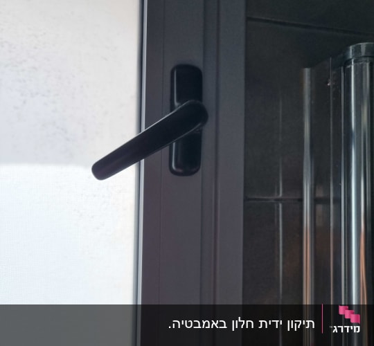 ידית תריס שחורה על חלון זכוכית